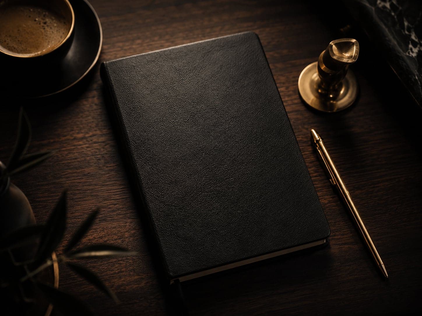 Al Ranim Properties advisory — a leather notebook, gold pen and coffee on a dark walnut desk