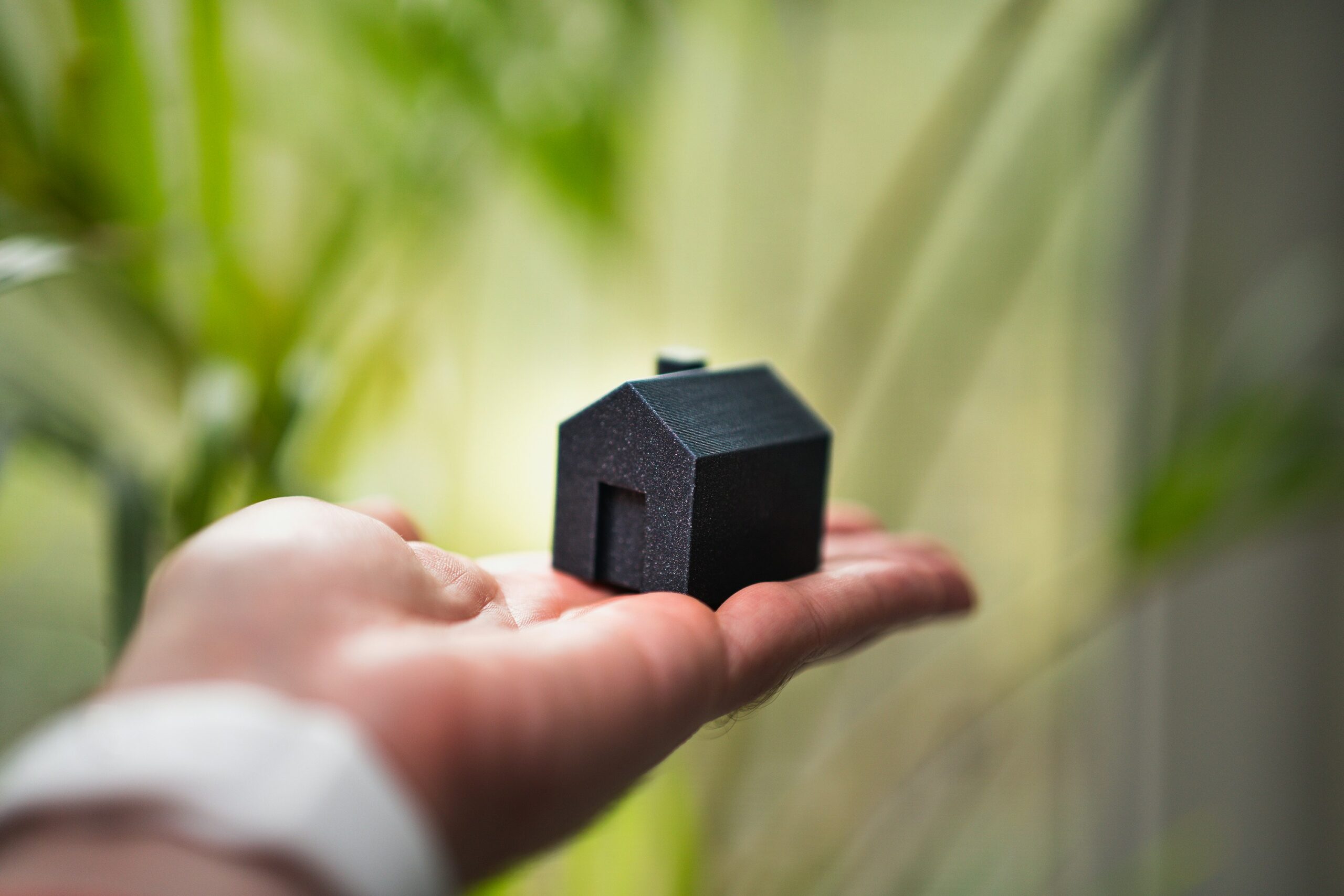 Hand holding a model house, symbolising the future of Dubai real estate careers