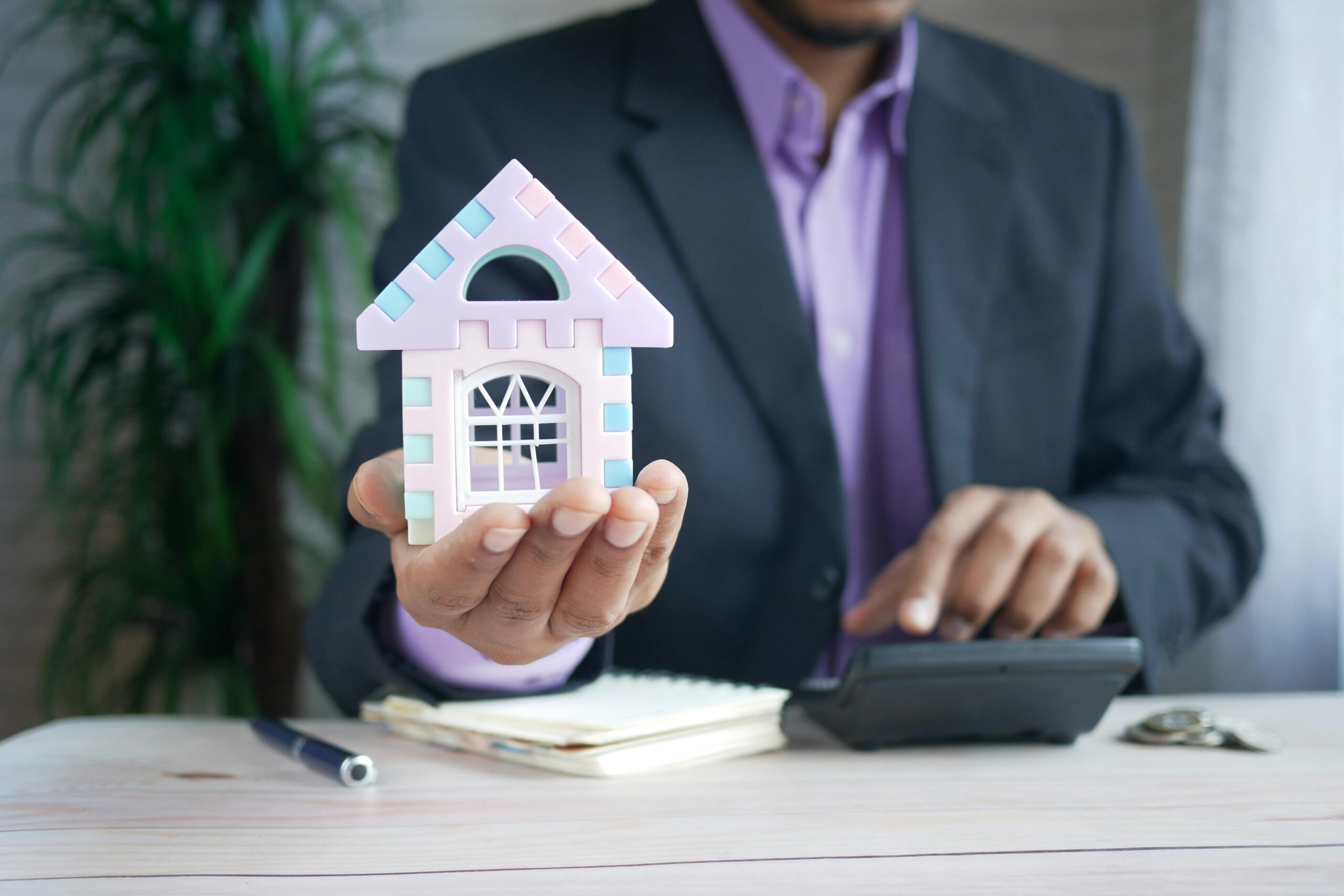 A model house and a calculator representing the costs of selling property in Dubai