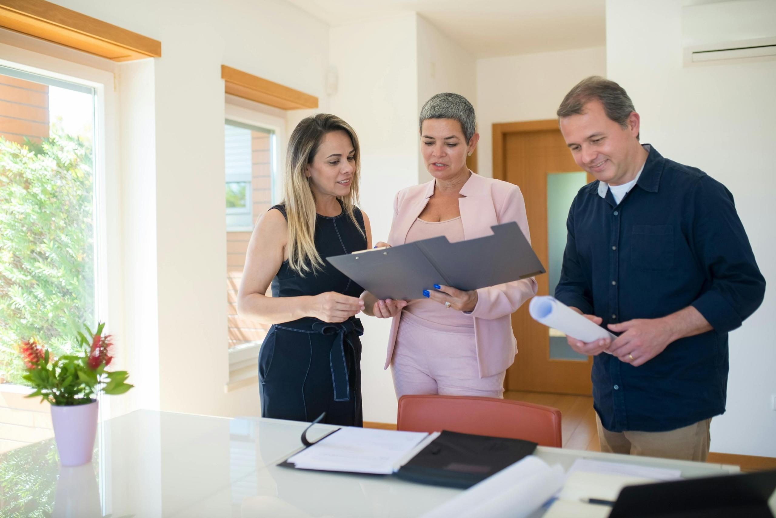 A real estate agent reviewing property documents with clients in Dubai